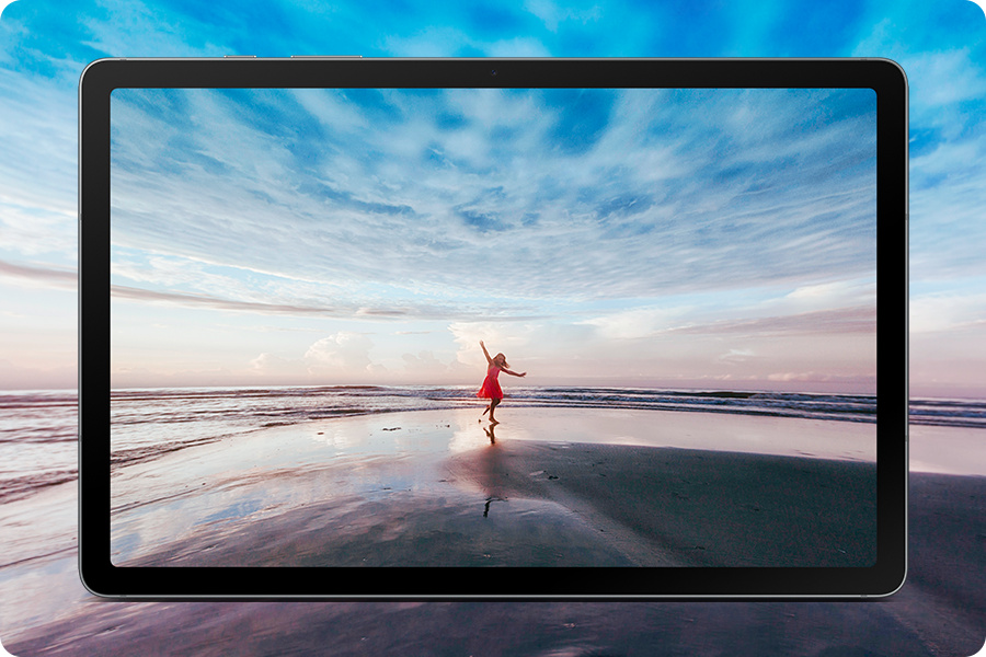 Veja mais em uma tela de 10,9 - 
Galaxy Tab S10 Lite exibido horizontalmente mostrando uma imagem vívida de uma mulher de vestido vermelho na praia com os braços estendidos contra um céu azul e o horizonte do oceano, expressando um clima de espírito livre. A cena expansiva se estende além das bordas da tela, destacando a grande tela de 10,9” e a experiência de visualização imersiva que dá vida ao conteúdo.
